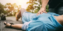 Secouriste effectuant la RCR sur une personne inconsciente au sol.