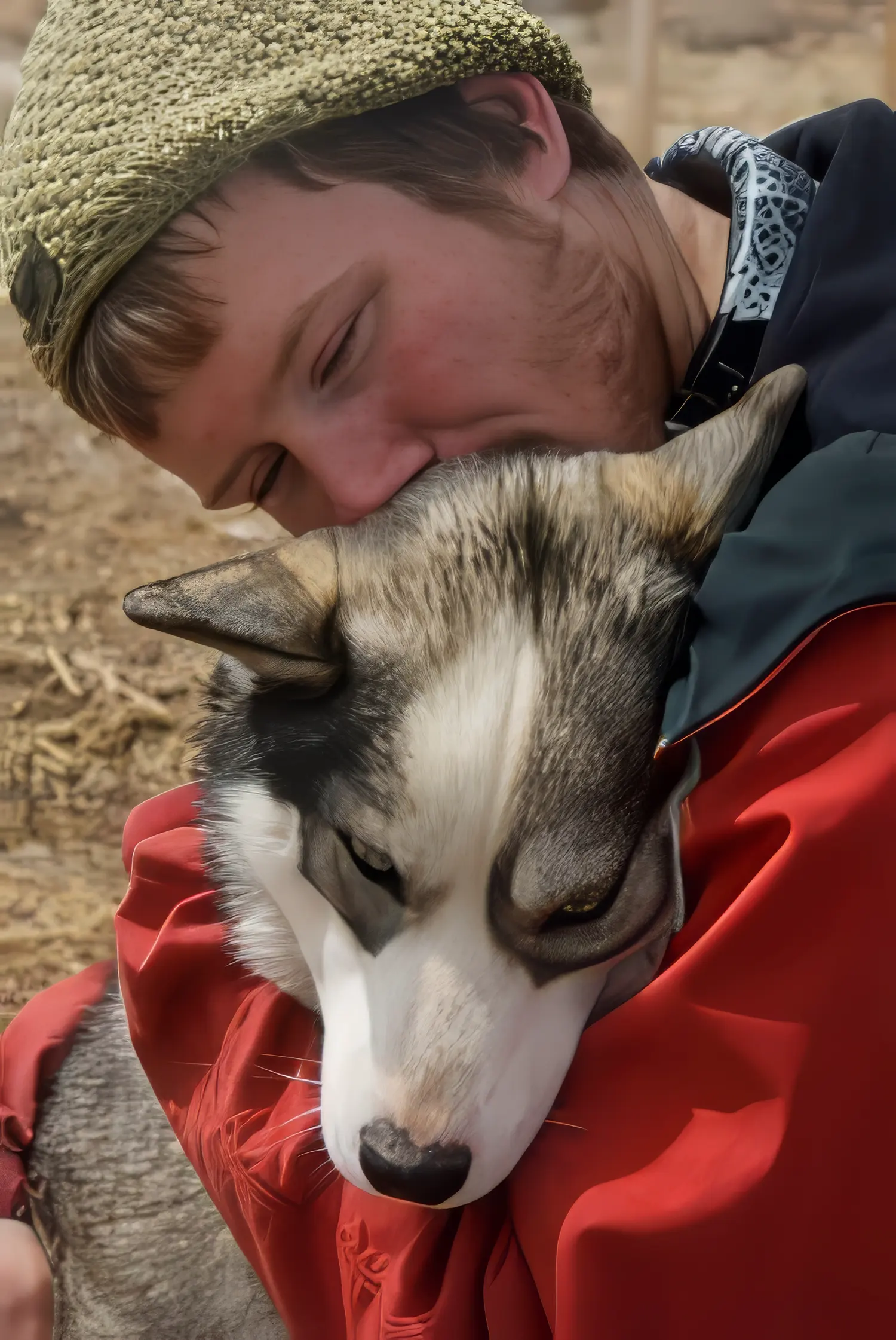 Personne embrassant un chien husky affectueusement